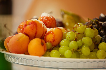 Naklejka na ściany i meble tasty fruit on a plate with pears, grapes, apricots