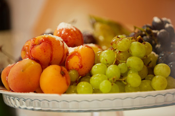 tasty fruit on a plate with pears, grapes, apricots