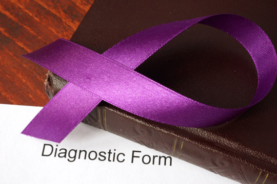 Pancreatic cancer diagnosis.  Awareness purple ribbon on a book.