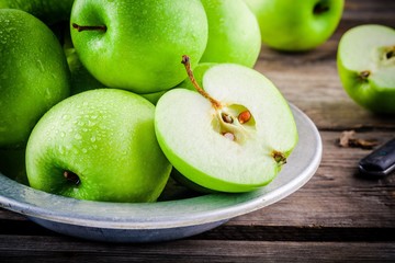 organic green apples on rustic wooden background