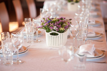    table setting in restaurant with flowers and wineglasses