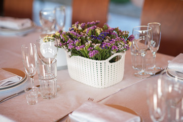    table setting in restaurant with flowers and wineglasses