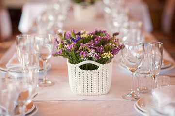    table setting in restaurant with flowers and wineglasses