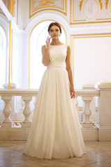 Fototapeta na wymiar beautiful young woman bride in luxury wedding dress in interior