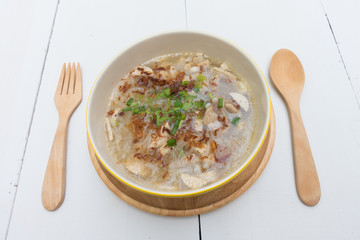 Traditional Vietnamese Noodle pork soup on a wooden background.

