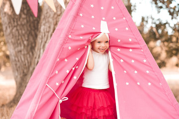 Smiling baby girl 3-4 year old playing outdoors in wigwam © morrowlight