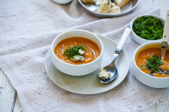 Butternut squash soup in bowls. Sweet potato creamy soup with fresh herbs. 