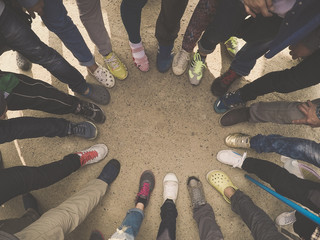 Top view of feet of people standing in a circle. Runners standing in a huddle with their feet...
