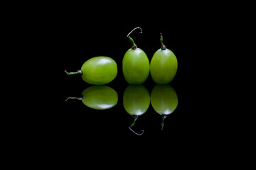 Three green grapes isolated on black background
