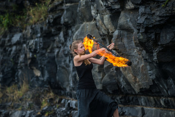 Girl in a black suit with flaming torches .