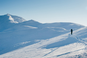 Naklejka na ściany i meble Single tourist climb to the snow-capped mountain top in the Carp