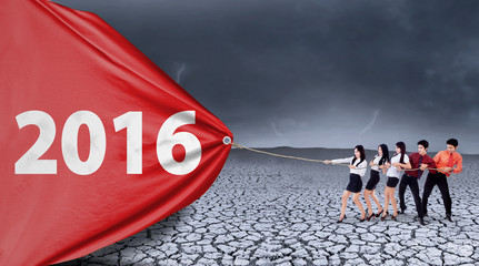 Business partners pulling numbers 2016 with a banner