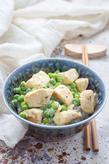 Fried chicken with green peas in cream sauce, served with rice, vertical, copy space