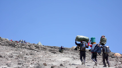 porters carrying equipment to the high camp on Kilimanjaro in Tanzania