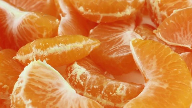 Rotating peeled tangerine slices closeup