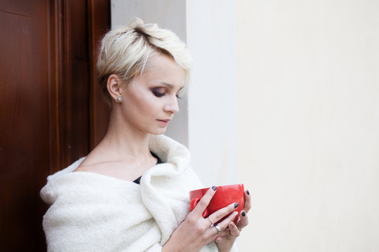 beautiful woman wrapped in a blanket with a cup in his hands