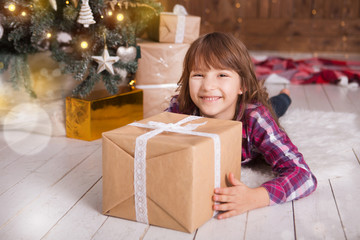 Fototapeta na wymiar Little girl with Christmas gifts near a Christmas tree
