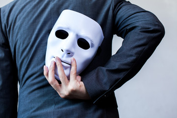 Business man carrying white mask to his body indicating Business fraud and faking business...