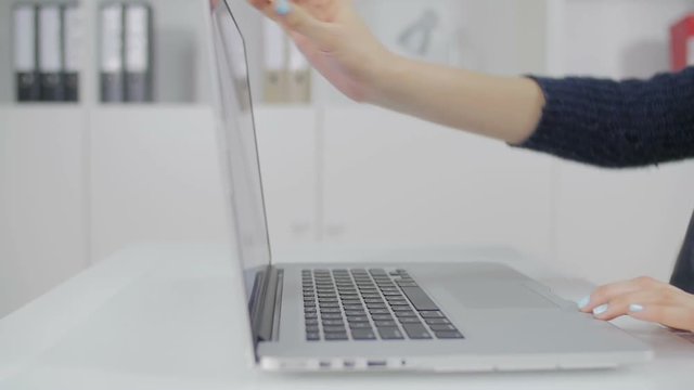 The girl with beautiful manicure opened the laptop