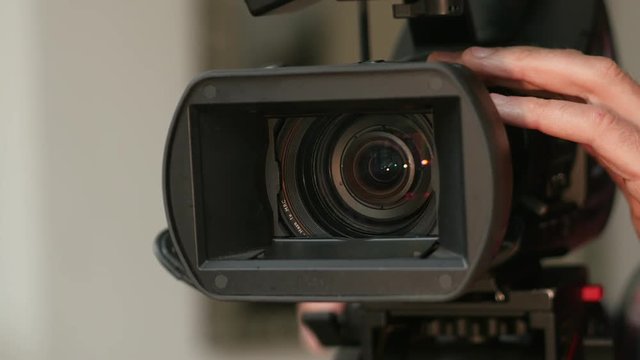 Broadcast ENG camera. Detail of lens, hood and hand turning control ring.