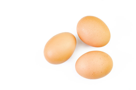 Three brown eggs isolated on white.