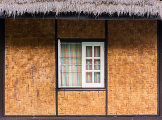 Vintage wooden window, twill weave wall and thatched roof. The traditional home design in Thailand, Asia.