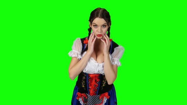 Bavarian girl in a suit shows emotion of surprise. Green screen