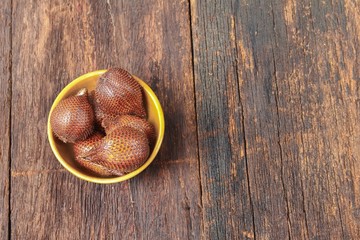 Salak fruit, Salacca zalacca in cup on the wooden floor background