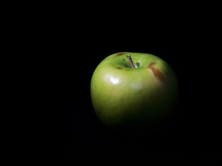 Green apple on black background