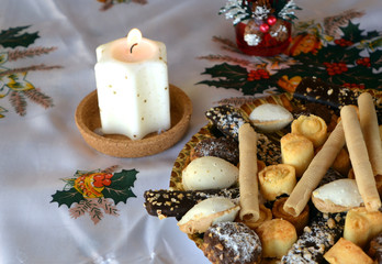 Christmas cookies with coconut on a table with lighted candles