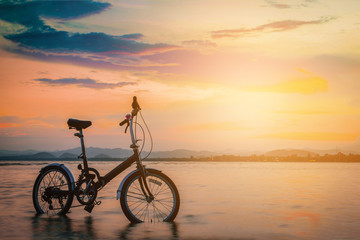 Silhouette bicycle on the beach at sunset. Vintage tone