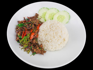 Rice topped with stir fried hot and spicy pork with basil isolated on the black background with clipping path