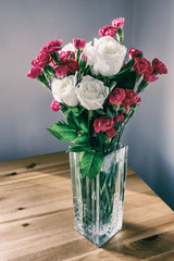 Bouquet of white roses and cloves in glass vase