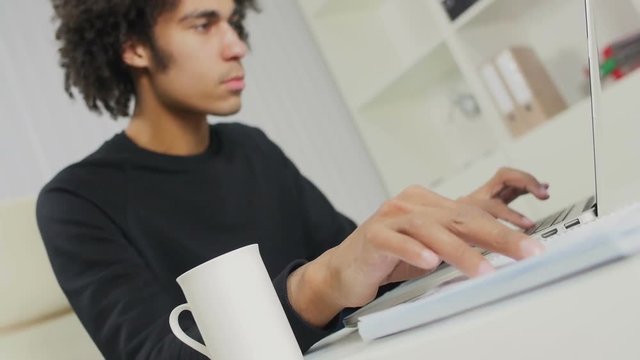 Afro-American reads the text in a notebook and prints it on the computer