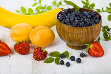 Ripe fruit and berries: bananas, blueberries, apricots, strawber
