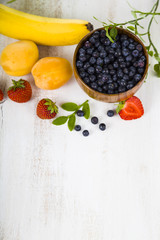 Ripe fruit and berries: bananas, blueberries, apricots, strawber