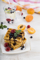 Belgian waffles with raspberries, blueberries and mint, covered