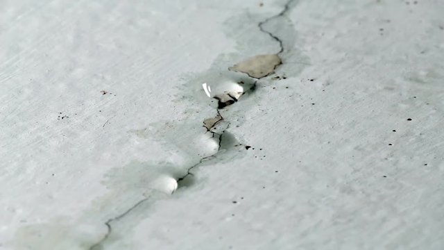 Water drips from ceiling. Faulty water supply in high-rise building. Cracked plaster on the ceiling.