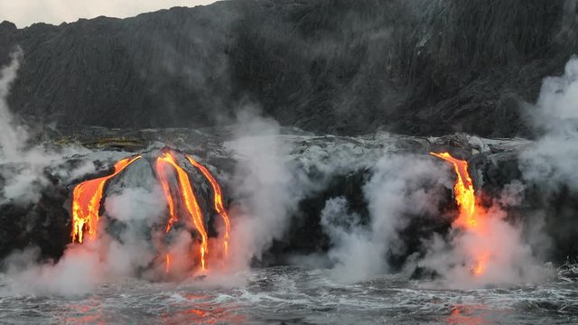 Lava flowing in the ocean from volcanic lava eruption on Big Island Hawaii. Seen from lava boat tour. Lava from Kilauea volcano by Hawaii volcanoes national park, USA. Dawn, steadicam, 59.94 FPS. 2016
