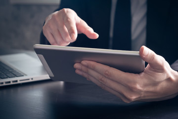 Close up of Businessman using tablet on the office desk.