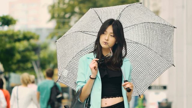 Thinking asian girl city portrait.