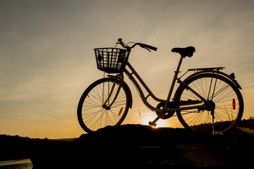 Silhouette of Bicycle with beautiful landscape at sunset or sunr