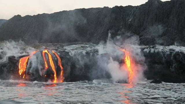 Lava ocean - flowing lava reaches ocean on Big Island, Hawaii. Lava stream seen from the water flowing from Kilauea volcano near Hawaii volcanoes national park, USA. 59.94 FPS, Steadicam. Year 2016.