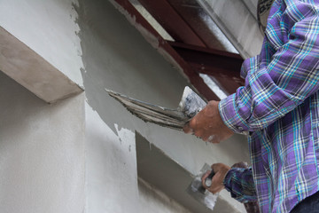 plasterer concrete worker at wall of house construction 