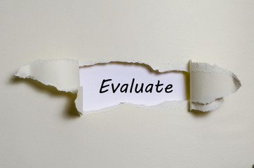The word evaluate appearing behind torn paper