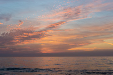 High clouds lit by the sunset over the sea