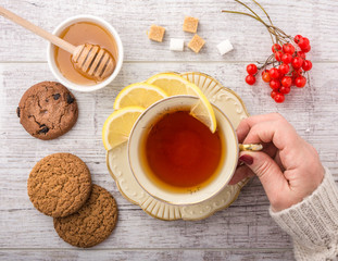 woman drinking tea with lemon closeup