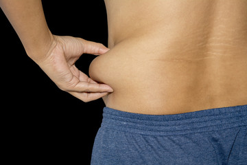 Naklejka premium Excess fat around the waist isolated on black