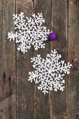 White snowflake and New Year's ball on a wall from old boards