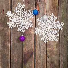 White snowflake and New Year's ball on a wall from old boards